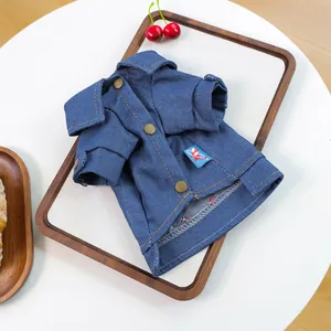 Dettaglio giacca di jeans blu scuro per animali con bottoni in metallo e cuciture arancioni