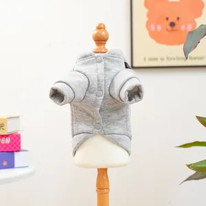 Détail d'un sweat à capuche gris pour animal avec boutons sur cintre en bois
