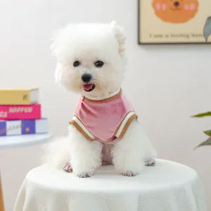 Close-up of pink velvet pet vest with ribbed brown collar on a white dog