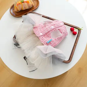 Dettaglio dell'abito per cani in tweed rosa con tutu in tulle e bottoni per animali