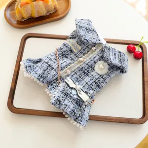 Détail de robe en tweed pour animaux avec boutons perles, broche camélia et ruban