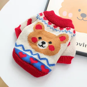 Detail of knitted pet sweater featuring a brown bear motif and red heart patterns