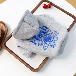 Detailansicht grauer Hunde-Hoodie mit blauer Gänseblümchen-Stickerei und Strickstoff