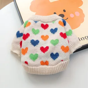 Primer plano de la textura de punto y patrones de corazones coloridos en el suéter de perro
