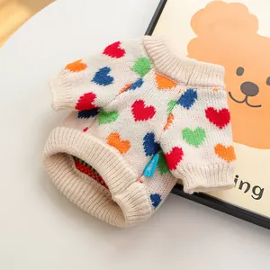 Detalle de un suave suéter beige para mascotas con corazones de colores y puños elásticos
