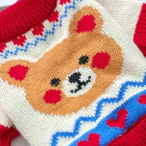 Close-up of multicolored knit pet sweater showing crochet bear detail and ribbed cuffs