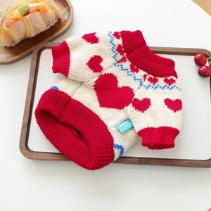 Close-up of heart pattern knit sweater for small dogs with blue wavy textured trim