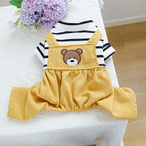 Detail of yellow corduroy pet overalls with striped sleeves and bear embroidery