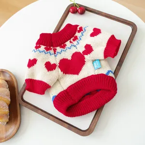 Detailed knit texture of a pet sweater with red hearts and blue wave patterns