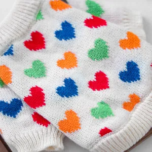 Detalle de suéter de punto para mascotas con corazones coloridos y cuello acanalado