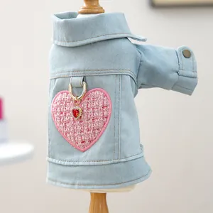 Detalle de chaqueta vaquera para mascota con parche de corazón rosa y gema roja
