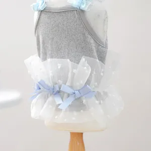 Detalle de vestido para perro con cuerpo gris acanalado, tutú de tul y lazos azules.