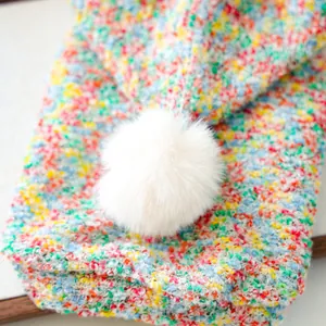 Close-up of colorful knit pet hoodie with soft white plush pom-pom and vibrant texture