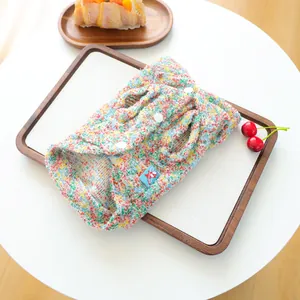 Close-up of colorful tweed pet vest with button closure and cute cartoon patch