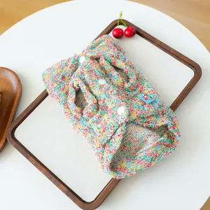 Close-up of colorful flecked fleece pet hoodie with white buttons on wood tray