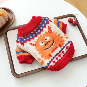 Detail of knit pet sweater featuring orange monster jacquard and red ribbed cuffs