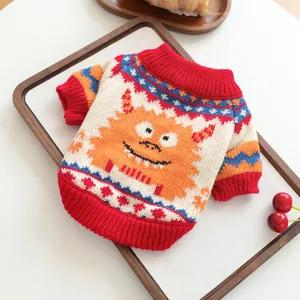 Detail of knitted pet sweater featuring a colorful orange monster jacquard pattern