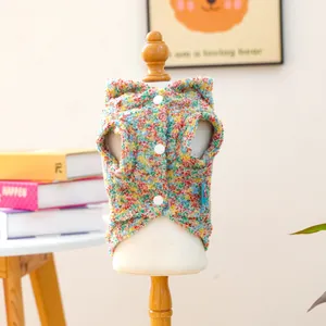 Close-up of colorful knit pet vest with three white buttons and warm textured fabric