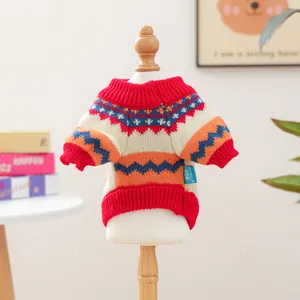 Macro detail of Fair Isle knit pet sweater with colorful patterns and ribbed red collar