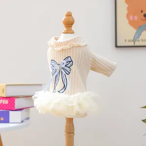 Detail of cream pet dress with blue plaid bow and layered white mesh tutu skirt