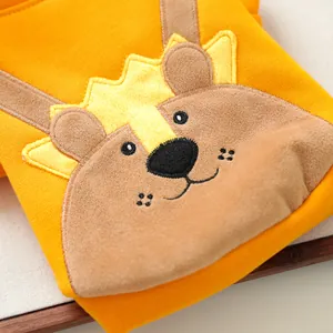 Détail d'un pull jaune pour animaux avec écusson ours en 3D doux et broderie fine