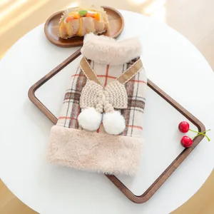 Detailed view of plaid pet sweater with cozy faux fur collar and cute pompom bow accents