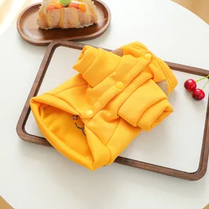 Détail du sweat-shirt jaune pour animaux avec broderie smiley et fermeture par boutons