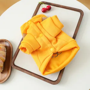 Gros plan d'un sweat à capuche jaune pour chien avec boutons pression