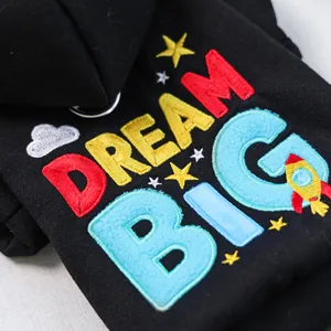 Detail of colorful DREAM BIG embroidery with towel stitch on black pet hoodie