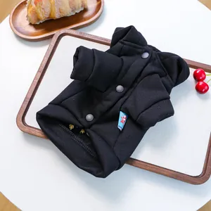 Detail of black pet fleece hoodie with snap buttons on a rustic wooden tray