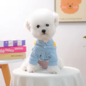 Chaqueta azul y amarilla para perros pequeños llevada por un Bichon Frisé blanco