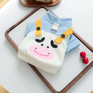 Detalle del chaleco de punto azul y blanco para mascotas con bordado de vaca y anillo en D de metal