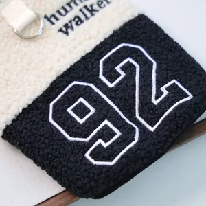Detail der Sherpa-Hundeweste mit D-Ring, Stickerei-Schriftzug und Nummer 92 Textur