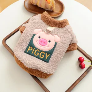 Detail of plush pet vest featuring pink pig embroidery and integrated metal D-ring leash attachment