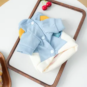 Detalle del chaleco de punto azul y blanco para mascotas con correas amarillas y botones
