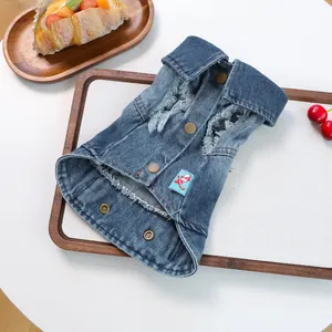 Detail van het blauwe denim huisdierenvest met modieuze gaten en draak-embleem
