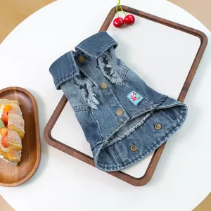 Detailweergave van retro denim hondenkleding met trendy gaten en koperen drukknopen
