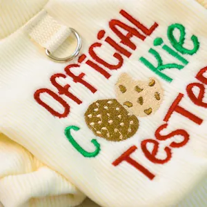 Detail of beige ribbed fabric with Official Cookie Tester embroidery and metal D-ring