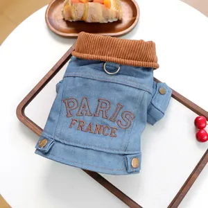 Detail of blue denim pet jacket with PARIS embroidery and metal D-ring for small dogs