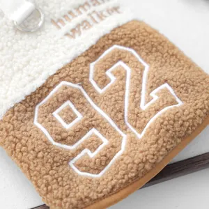Detail der flauschigen Lammwolltasche für Haustiere mit Stickerei und weicher Textur