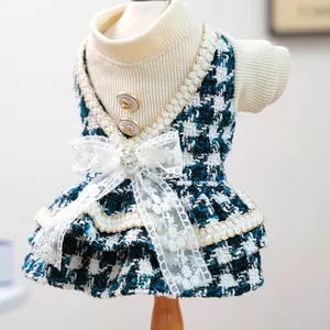 Détail de la robe pour animal en tweed bleu avec nœud en dentelle et boutons dorés
