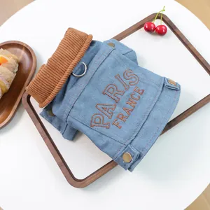Close-up of Paris denim dog jacket featuring brown ribbed collar and metal D-ring attachment
