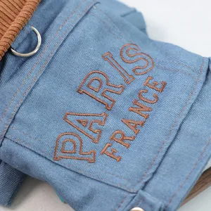 Detail of blue striped pet denim coat with Paris embroidery and metal D-ring attachment