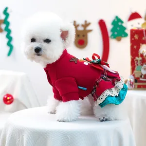 Détail de robe de Noël pour chien avec patch élan, jupe écossaise et bordure en dentelle