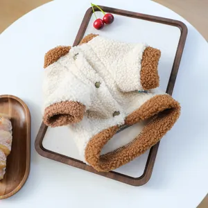 Detail eines flauschigen Lammwoll-Haustierpullovers mit braunem Saum und Knöpfen