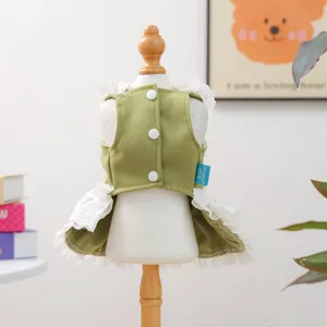 Détail d'une robe verte pour animal avec bordure en dentelle blanche et boutons au dos