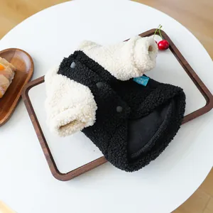 Detailed view of bicolor lamb wool pet sweater with black resin snap buttons and brand tag