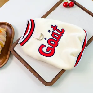 Detail of cream corduroy pet vest featuring GOAT embroidery and metal D-ring for leash