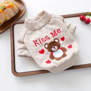 Détail du pull en tricot beige pour animaux avec broderie ours et bords côtelés