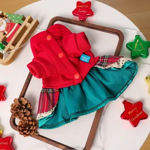 Détail d'une robe de Noël pour animaux rouge et verte avec dentelle sur plateau bois